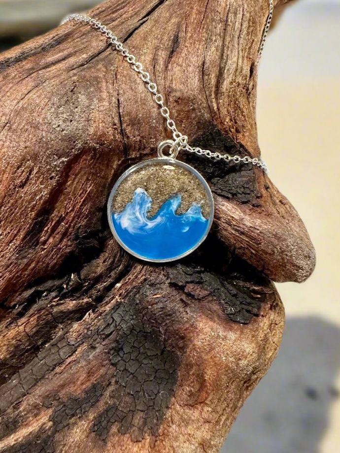 This is a picture of pendant necklace made with real California sand and resin representing Long Beach.