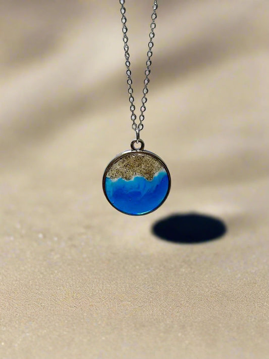 This is a silver pendant necklace made with real california sand representing the Malibu coastline.