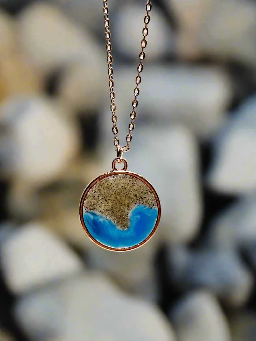 This is a picture of a pendant necklace representing the coastline of Pebble Beach, CA