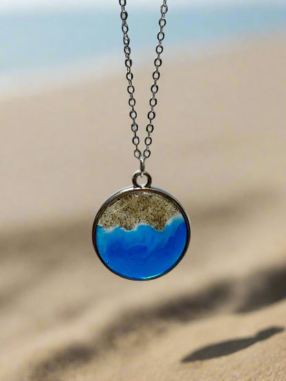 This is an image of a pendant necklace. Round pendant with genuine socal sand representing the santa barbara coast.