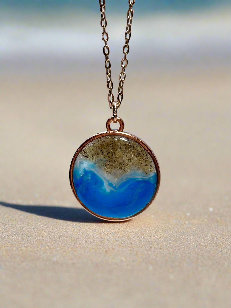 This is a picture of pendant necklace. Pendant is rose gold and inside is real sand and resin representing the santa barbara coast.