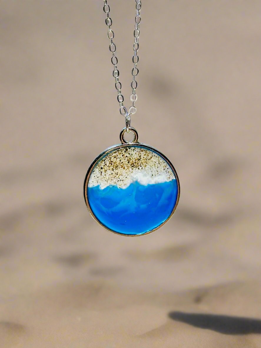 This is a pendant necklace made with genuine socal sand and resin representing the coast of Santa Cruz, CA.