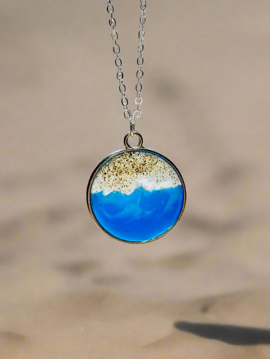 This is a pendant necklace made with genuine socal sand and resin representing the coast of Santa Cruz, CA.