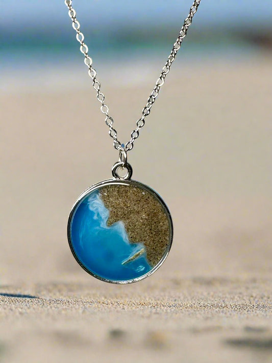 This is a photo of a pendant made with real California sand and resin representing Venice Beach.