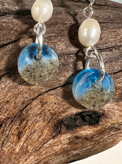 This is a closeup of the circle drop earrings, freshwater pearl accent, sand and resin circle.