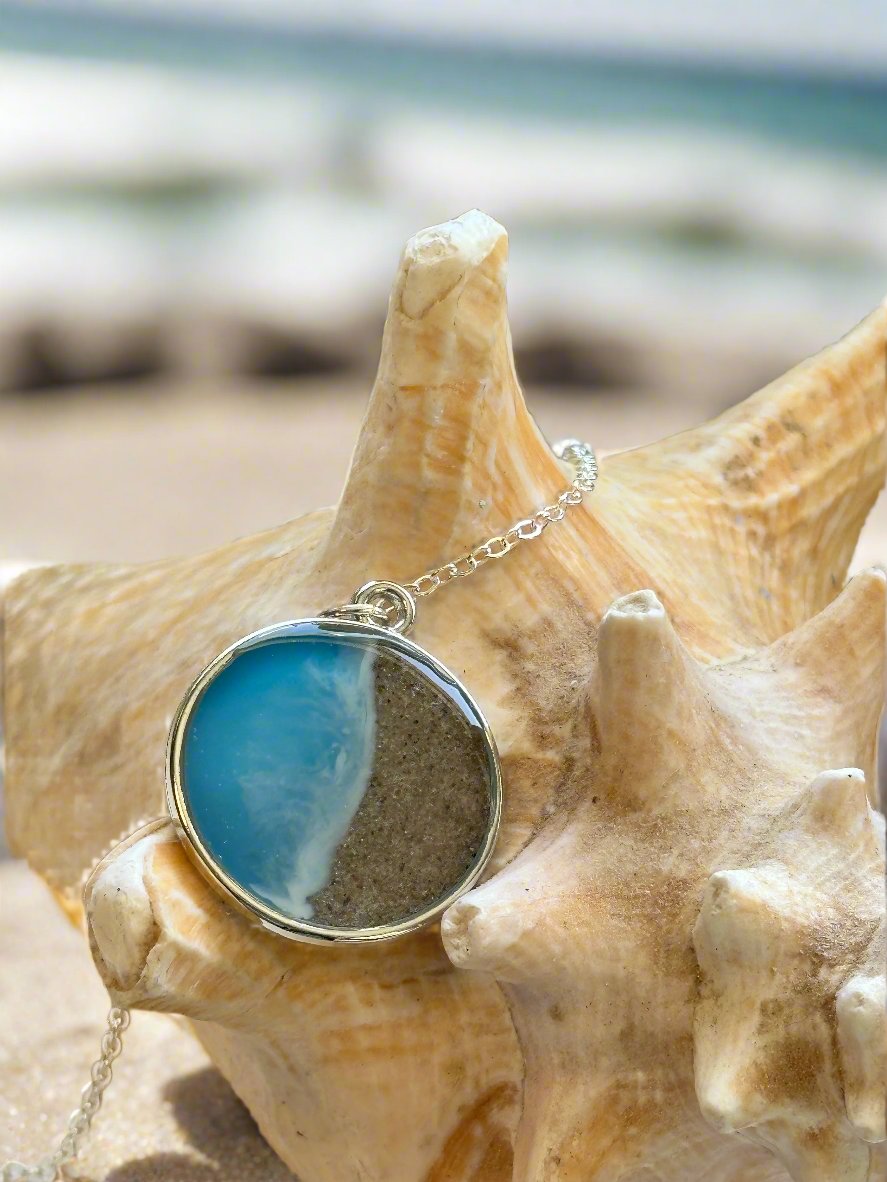 This a photo of a pendant necklace representing Half Moon Bay in California.